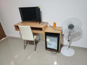 a desk with a computer monitor and a fan at Soares Stay in Tarrafal