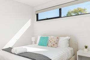 a bedroom with a white bed with a window at Mid-Century Home Near Hospital and Woden - Hosted by Canstay in Phillip