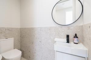 a bathroom with a white sink and a mirror at Mid-Century Home Near Hospital and Woden - Hosted by Canstay in Phillip