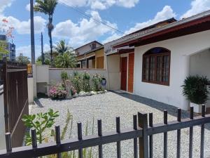 a house with a fence in front of it at Cantinho do silêncio in Joinville