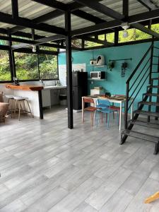 a kitchen and dining room with a wooden floor at Cabaña Piamonte Villeta in Villeta