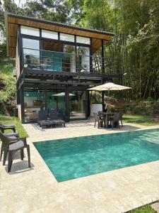 a house with a pool and a table and chairs at Cabaña Piamonte Villeta in Villeta