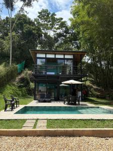 a house with a pool in front of it at Cabaña Piamonte Villeta in Villeta