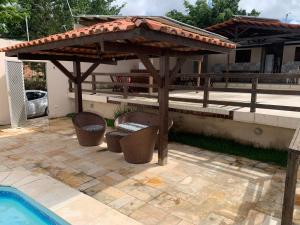 a wooden pergola sitting next to a swimming pool at Espaço Victoria in Caruaru