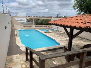 a swimming pool with an umbrella on a patio at Espaço Victoria in Caruaru