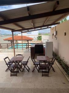 a patio with tables and chairs under a roof at Espaço Victoria in Caruaru