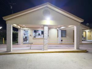 a large building with a garage at night at Relax Inn Bryan College Station in Bryan