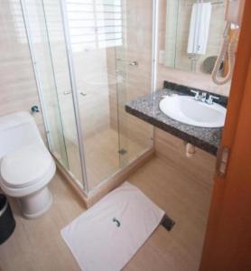a bathroom with a shower and a toilet and a sink at Hotel Jardin in San Cristóbal +28 photos