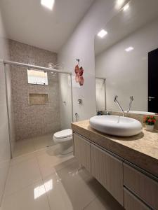 a bathroom with a sink and a toilet at Casa Aconchego Lar in Rio Verde +15 photos