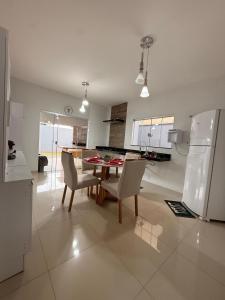 a kitchen and dining room with a table and a refrigerator at Casa Aconchego Lar in Rio Verde