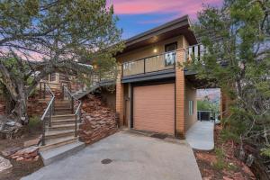 a brick house with a garage and a tree at Perfect Couples Getaway Private Hot Tub Panoramic Red Rock Views in Sedona +24 photos