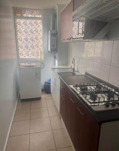 a kitchen with a sink and a stove top oven at Refugio inca in Cusco