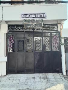 ein Paar schwarze Türen zu einem Laden mit einem Schild darauf in der Unterkunft Solmana Suites in Sampong + 18 Fotos
