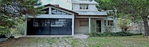 a white house with a black garage door at Casa Nur in Potrerillos
