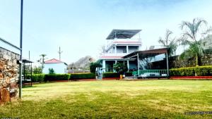 a large house with a lawn in front of it at Anantiva Farms in Rāma