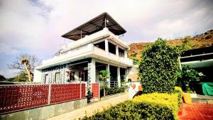 a white house with a red fence in front of it at Anantiva Farms in Rāma