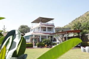 a white building with a roof on top of it at Anantiva Farms in Rāma