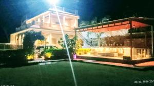 a fountain in front of a house at night at Anantiva Farms in Rāma