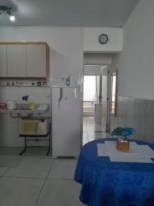 a kitchen with a refrigerator and a table in it at Apartamento em Lauro de Freitas in Lauro de Freitas