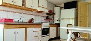 a kitchen with white cabinets and a white refrigerator at Casa Nur in Potrerillos +14 photos