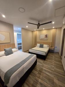 a hotel room with two beds and a ceiling fan at Amoblados la 19 in Ríohacha