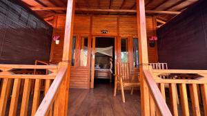 a porch of a wooden cabin with wooden railing at Dewi Teduh Villa in Sidemen