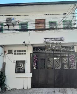ein Gebäude mit einer schwarzen Tür und einem Schild darüber in der Unterkunft Solmana Suites in Sampong