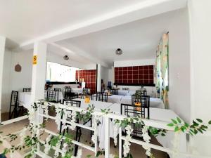 ein Esszimmer mit weißen Tischen und Stühlen in der Unterkunft Solmana Suites in Sampong