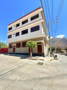 a white building with a tree in front of it at Refugio del Viajero in Carhuaz