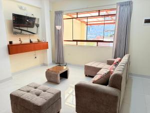 a living room with two couches and a tv at Refugio del Viajero in Carhuaz