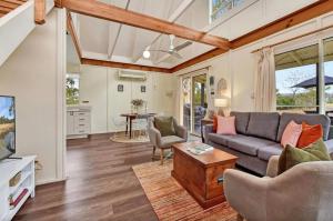 a living room with a couch and a table at The Meadow Suite in Pokolbin