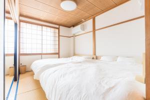 two beds in a room with two windows at オオジンマチ ハイツ302 in Takayama