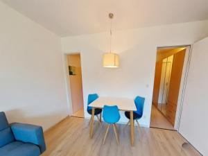 a dining room with a table and blue chairs at Studio Roswitha mit Pool und Sauna in Freyung