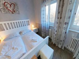 a small bedroom with a white bed and a window at Studio Martina mit Pool und Sauna in Freyung