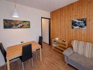 a living room with a dining room table and a couch at Studio Sebastian mit Pool und Sauna in Freyung