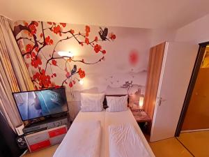 a hotel room with a bed and a tv at Studio Rainer mit Pool und Sauna in Freyung