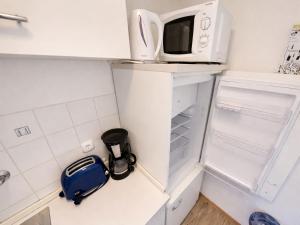 a small kitchen with a refrigerator with a microwave at Studio Robert mit Pool und Sauna in Freyung