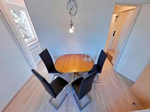 a dining room with a wooden table and black chairs at Studio Roswitha mit Pool und Sauna in Freyung
