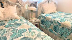 a bedroom with two beds and a table with a lamp at Rulons Cape May Diamond, 2Nd in Cape May