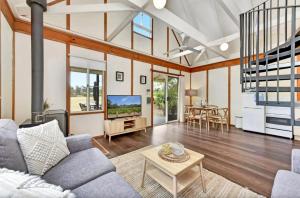 a living room with a couch and a table at The Orchard Suite in Pokolbin