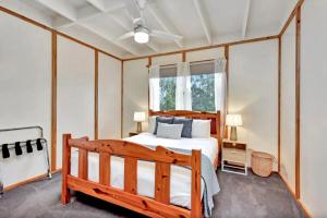 a bedroom with a wooden bed and a window at The Orchard Suite in Pokolbin