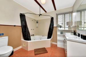 a bathroom with a tub and a toilet and a sink at The Orchard Suite in Pokolbin +2 photos