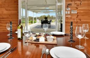 a table with wine glasses and a plate of food at The Ridge Stables in Pokolbin +10 photos