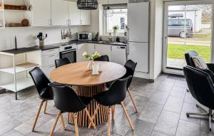 a kitchen with a wooden table and black chairs at Lovely Home In Ringkøbing With Kitchen in Ringkøbing