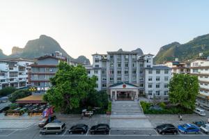 a view of a building with cars parked in a parking lot at Yangshuo YeQi Hotel in Yangshuo