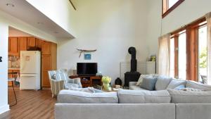 a living room with a white couch and a refrigerator at Songbird Sojourn in Cape May Point