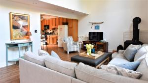 a living room with two couches and a kitchen at Songbird Sojourn in Cape May Point