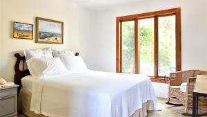 a bedroom with a white bed and a window at Songbird Sojourn in Cape May Point