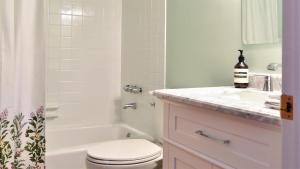a white bathroom with a toilet and a sink at Songbird Sojourn in Cape May Point +14 photos