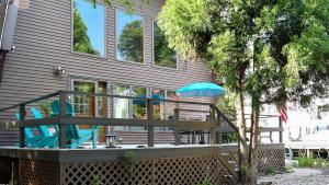 a porch with two chairs and an umbrella at Songbird Sojourn in Cape May Point